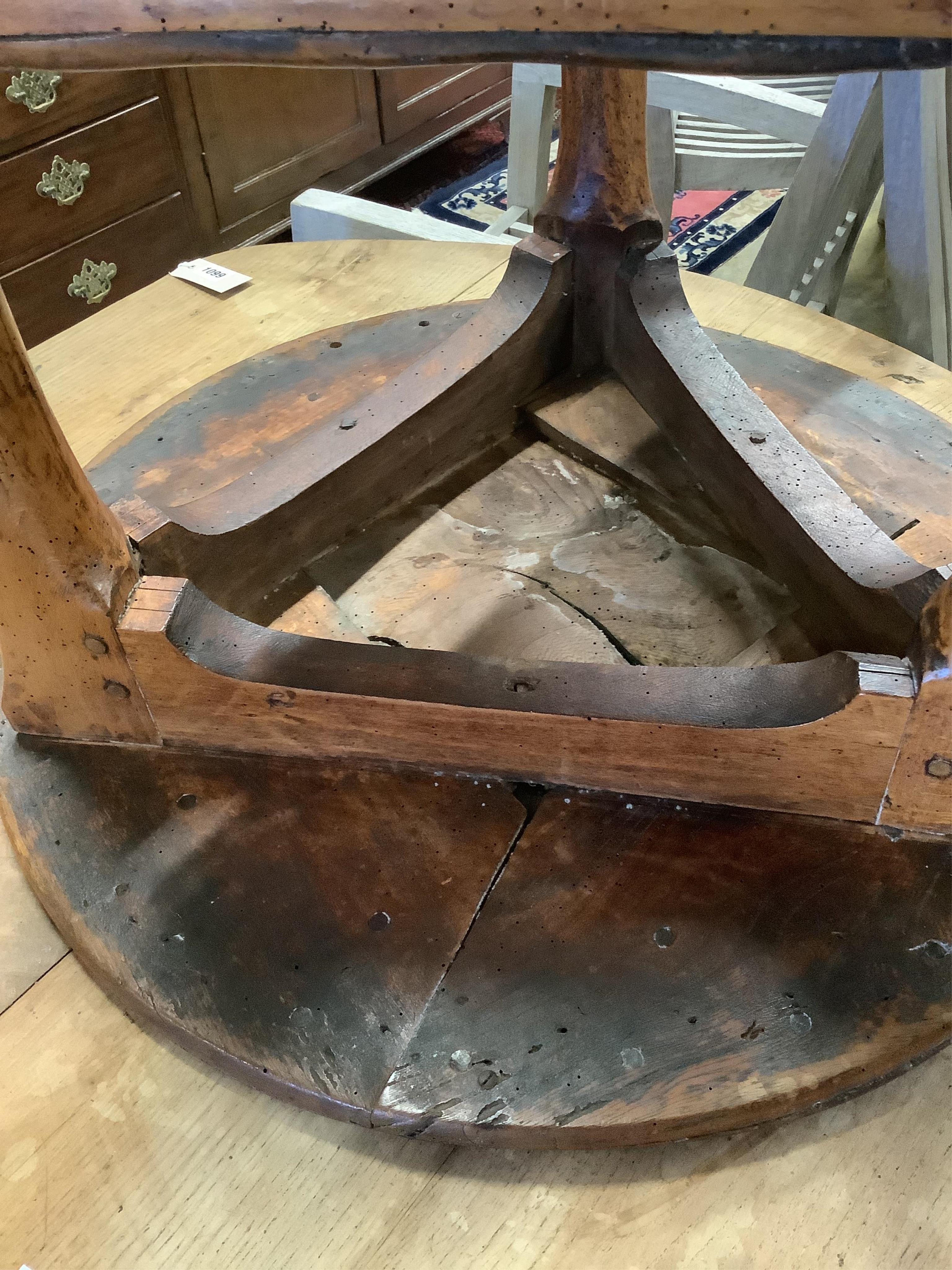 An 18th century elm cricket table, width 63cm, height 64cm. Condition - extensive splitting and old patches and repairs to the top, legs probably reduced, but full of character
